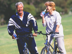 Man and woman riding bikes taking a break to take a drink of water