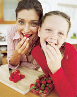Mother and daughter eating strawberries